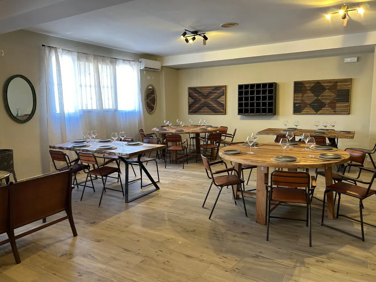 El salón de Casa Parra con mesas de madera montadas y luz natural