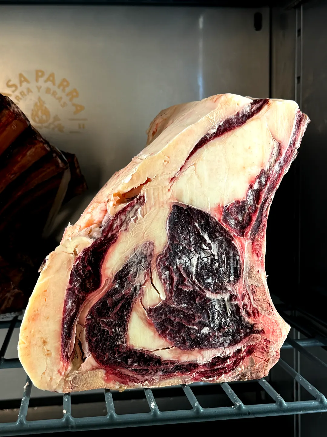 Pieza de vaca madurada con su grasa amarilla, en la cámara de maduración